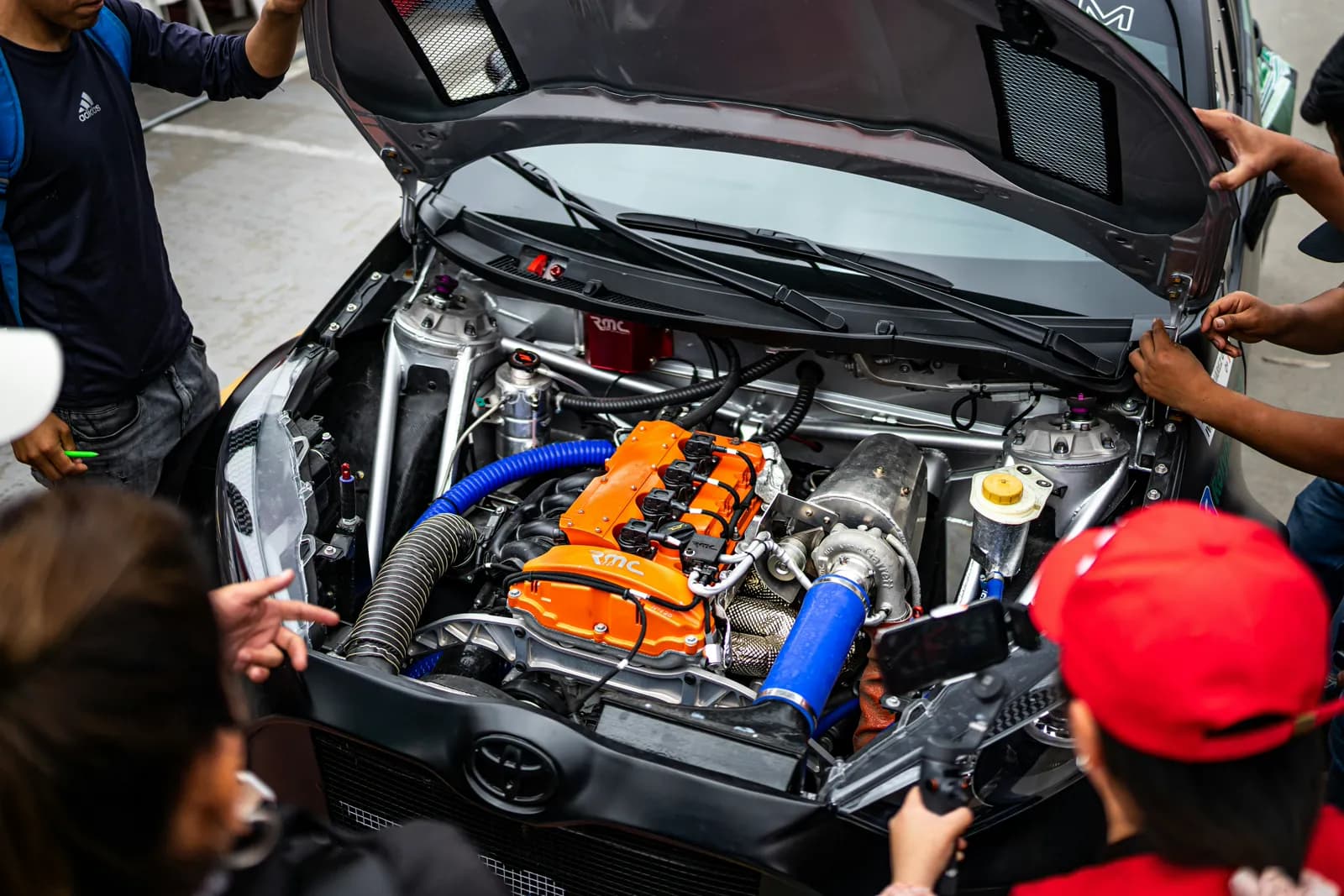 Engineers around an open engine bay on an automotive line