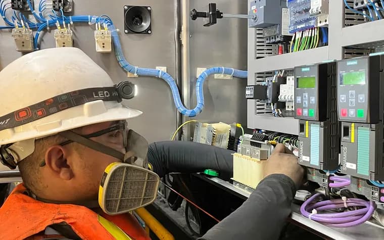 Reliability engineer taking readings from a plant control panel
